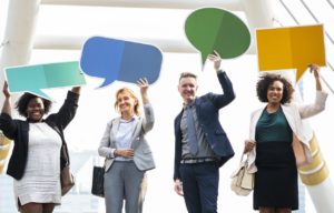 Three women and a man holding speech bubbles